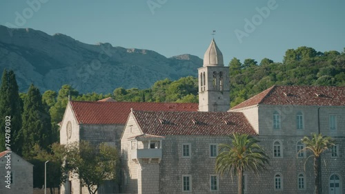Franciscan monastery with Mediterranean architecture and red rooftop on an island. Close-up shot of monastery bell tower.