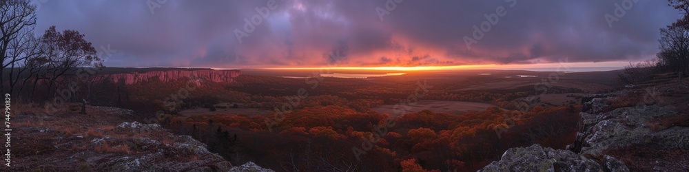 Expansive Panoramic View of a Fiery Sky Over an Undulating Landscape at Dawn, a Tapestry of Warm Colors