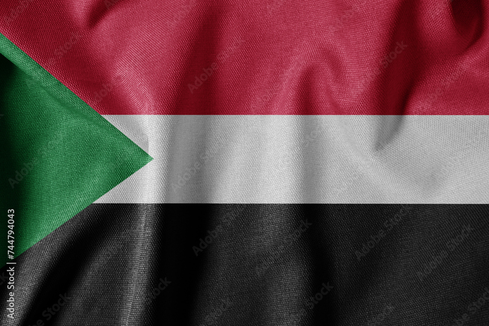 Fototapeta premium National Flag on Textured Fabric Background. Silk textured flag, realistic wave and flag look. SD Flag of Sudan