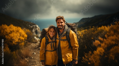 A man and woman smile by the mountainous landscape under a cloudfilled sky