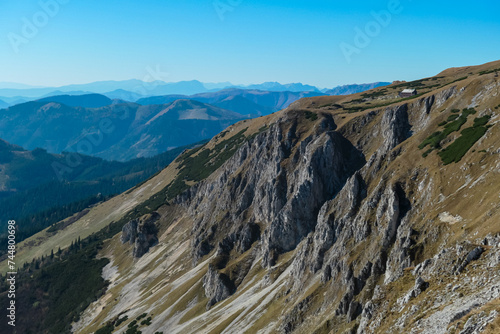 Panoramic view from top of mountain peak Hohe Veitsch in Mürzsteg Alps, Styria, Austria. Idyllic hiking trail in alpine terrain. Wanderlust in remote Austrian Alps in autumn. Cottage on rock formation photo