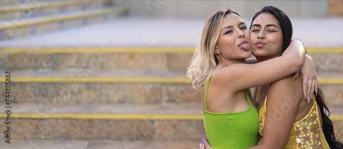 Two multiracial friends hug each other making funny face frienship concept