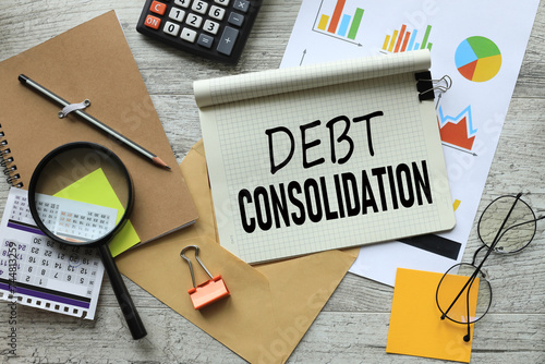 debt consolidation stationery and calculator on financial chart. text on notepad page with spiral
