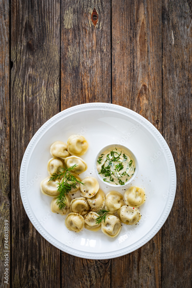 Pelmeni - dumplings filled minced meat on wooden table
Pelmeni - dumplings filled minced meat on wooden table