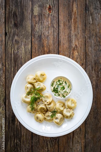 Pelmeni - dumplings filled minced meat on wooden table 