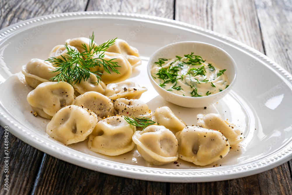 Pelmeni  - dumplings filled minced meat on wooden table
