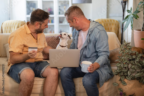 married couple buying food for their dog online while licking their lips