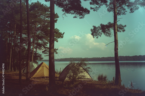 Camping Tents Near Lake, film camera style travel landscape, peaceful vintage photograph. © JW Studio