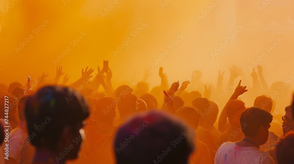 Fototapeta premium An orange Holi color over the crowd Holi festival concept