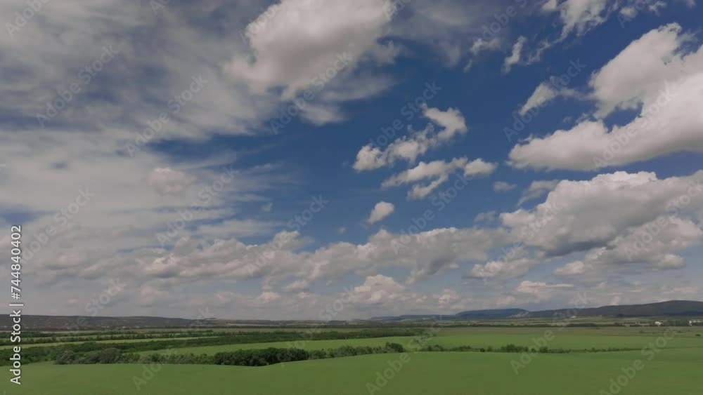 Aerial drone slowly advances over green landscape with beautiful clouds Aerial drone slowly advances over green landscape with beautiful clouds