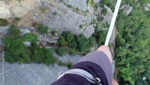 Concept of balance: The precipice at the base of the Bismantova stone seen from a tightrope walker on the slackline 200 meters above, Castelnovo nè Monti, Reggio Emilia, Italy photo