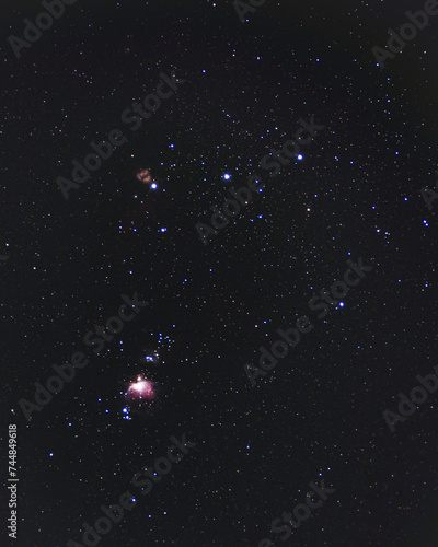 The Constellation Orion. Orion's Belt shining bright in the dark night sky. The Orion Nebula and the Flame Nebula are both visible as well as the running man and horsehead nebula being barely seen. photo