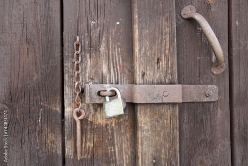 Quadro su tela Old lock at wooden door mixed with a modern padlock.