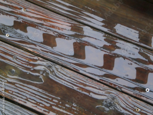 Reflections in rain puddles on old wooden deck