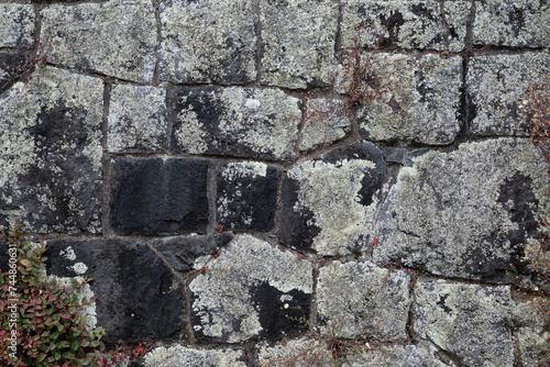 Natural background pattern, old rock wall as a rough background of old moss covered stones 