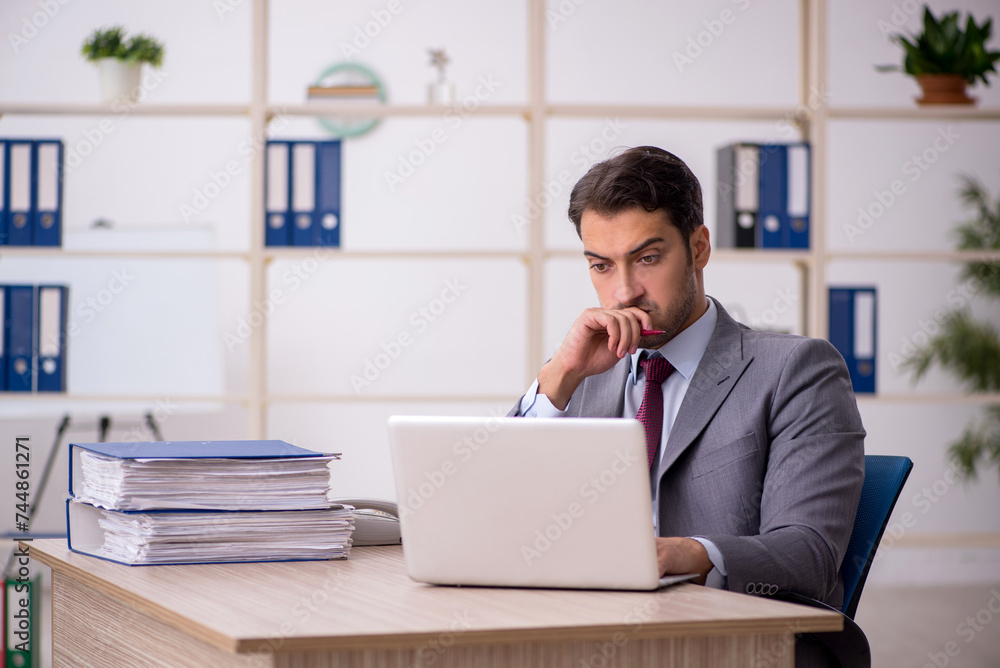 Young male employee working in the office Young male employee working in the office