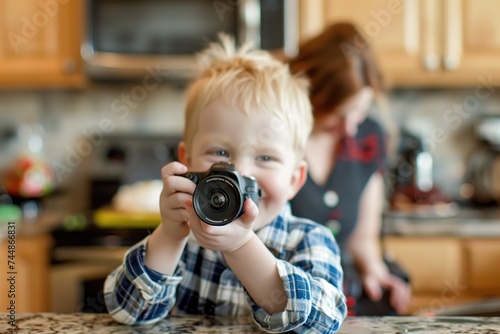 A boy with Down syndrome holds a camera up to his face, ready to take photos.