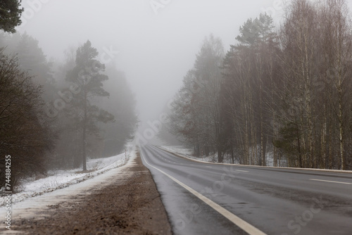 beautiful snow-covered road during fog in winter