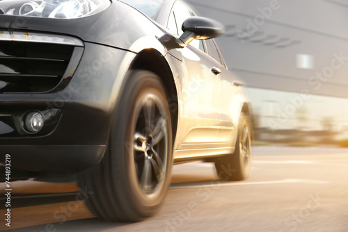 Black car driving on road outdoors, closeup with motion blur effect. Space for text © New Africa