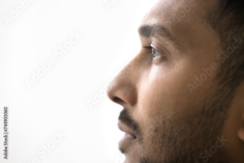 Close up profile photo of handsome serious Indian man on white gray studio background. Guy having attractive appearance, groomed beard look into distance, thoughts, ponders, memories, eyesight, vision