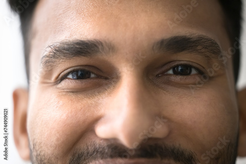 Close up front view face of happy millennial Indian brown-eyed man having attractive appearance optimistic mood, smile, looking at camera, advertising eye-care, vision correction, eyeglasses and lens photo