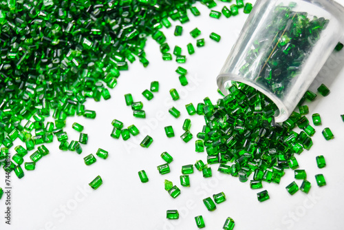 Transparent green masterbatch granules on a white background, this polymer is a colorant for products in the plastics industry photo