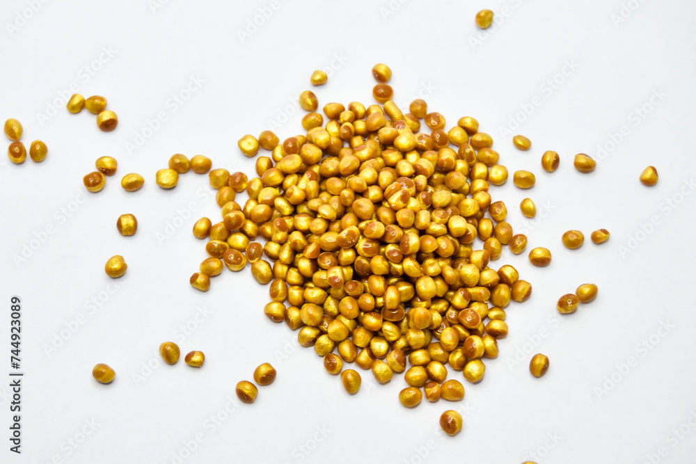 gold masterbatch granules on a white background, this polymer is a coloring agent for products in the plastics industry gold masterbatch granules on a white background, this polymer is a coloring agent for products in the plastics industry