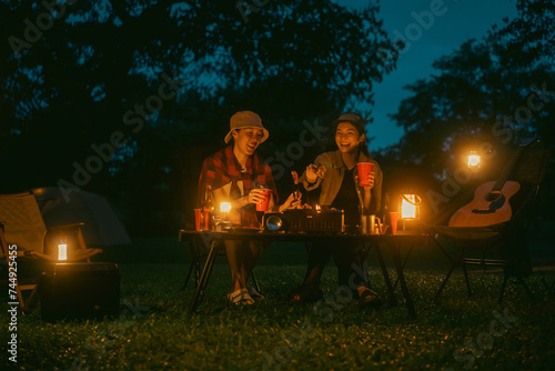 Cheers! Group of asian people friend party camping in nature making toasting with soft drink and beer red cup. Hangout party outdoor in campsite nature forest background on holiday weekend vacation