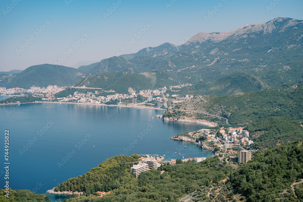Rugged coast of the Bay of Kotor at the foot of green mountains with resort towns. Montenegro