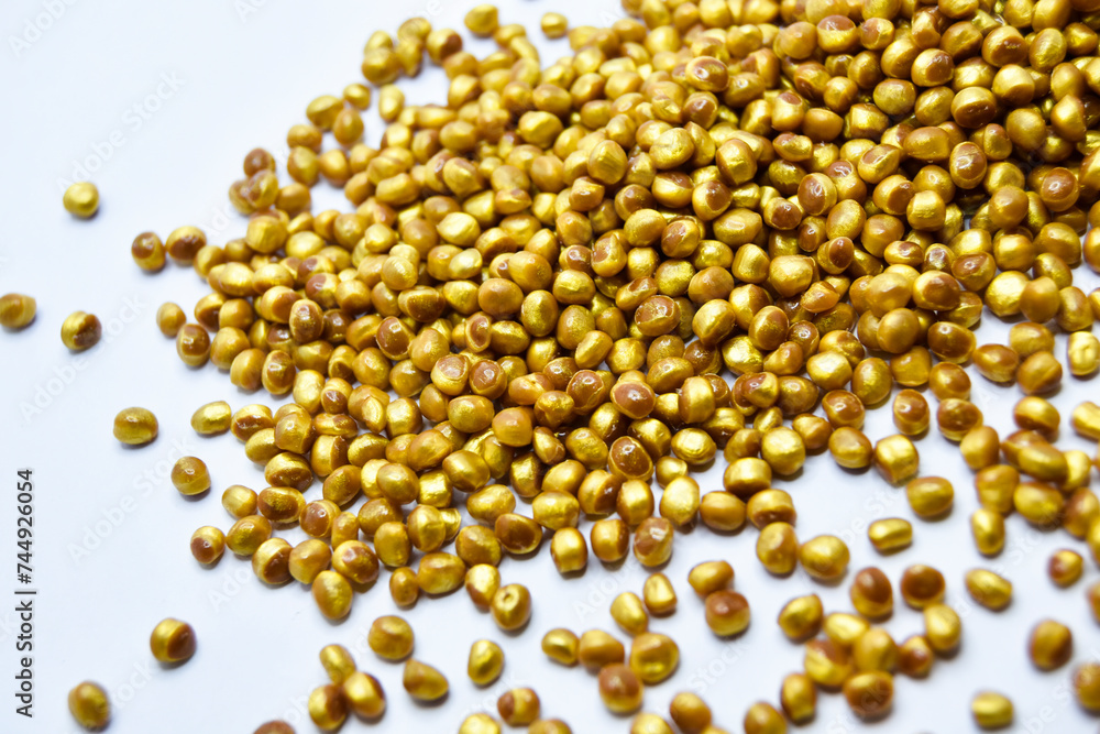 gold masterbatch granules on a white background, this polymer is a coloring agent for products in the plastics industry gold masterbatch granules on a white background, this polymer is a coloring agent for products in the plastics industry