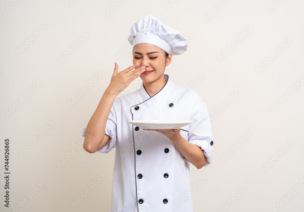 Bad smell and not tasty food. Young asian woman chef in uniform holding plate ladle utensils cooking in the kitchen various gesture on isolated. Cooking woman chef people in kitchen restaurant Bad smell and not tasty food. Young asian woman chef in uniform holding plate ladle utensils cooking in the kitchen various gesture on isolated. Cooking woman chef people in kitchen restaurant