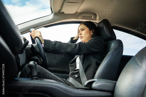 Driving during rush hour But the traffic is very congested. Angry face. Young asian businesswoman has broken down car on the road she feeling serious and stressed. Car crash Look for someone help. © Chanakon
