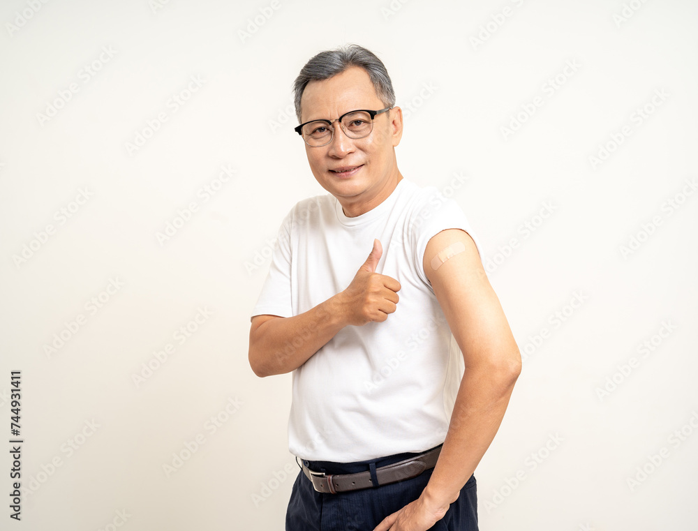 Senior man shows plastered shoulder arm after getting flu influenza vaccine. Mature Old people vaccination immunization. Health care medical. Senior man shows plastered shoulder arm after getting flu influenza vaccine. Mature Old people vaccination immunization. Health care medical.
