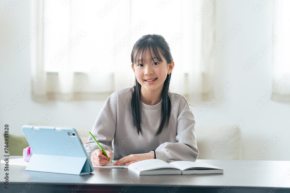 タブレットPCを見ながら勉強する女の子