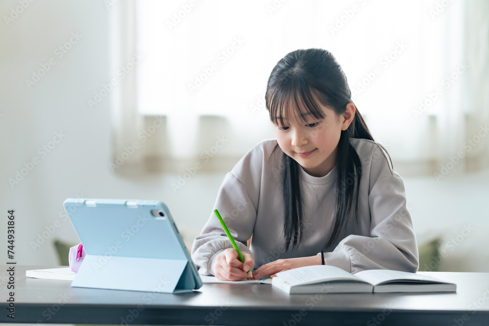 タブレットPCを見ながら勉強する女の子 タブレットPCを見ながら勉強する女の子
