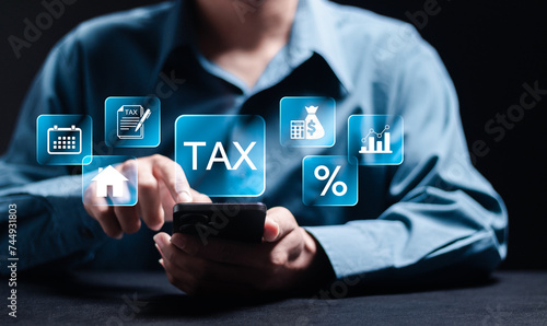 Paying tax concept. Filing online tax return form for payment. Calculation tax return taxes and VAT. Person use smartphone with TAX icon for calculates income to pay taxes to the government.