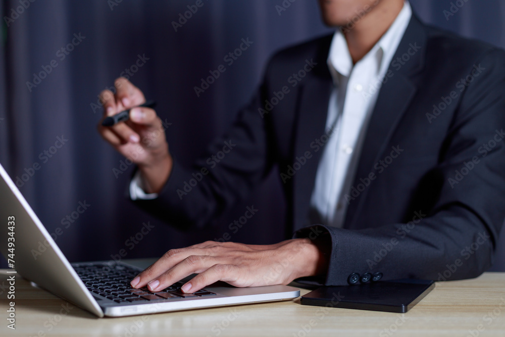 Businessman typing business success concept on laptop with key message pen and on computer keyboard.. Businessman typing business success concept on laptop with key message pen and on computer keyboard..