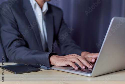 Businessman using laptop and typing on laptop computer keyboard in business success concept..