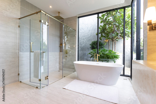 Luxury bathroom with white bathtub by the window  concept in a modern house