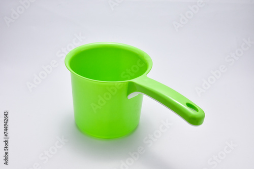 Green plastic ladle on a white background