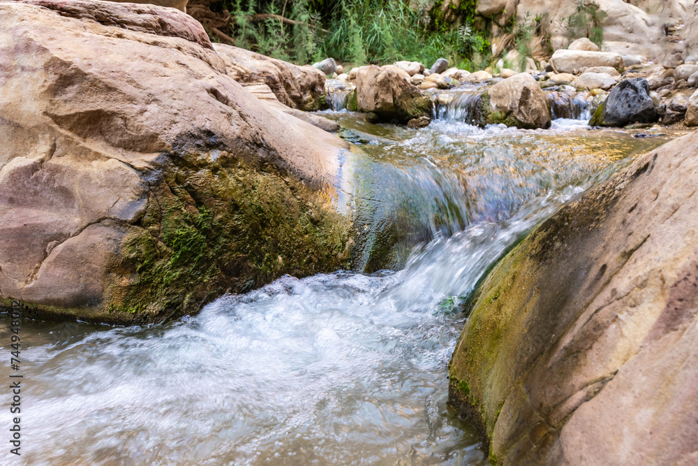 Small waterfall in path of shallow stream in gorge Wadi Al Ghuwayr or An Nakhil and the wadi Al Dathneh near Amman in Jordan Small waterfall in path of shallow stream in gorge Wadi Al Ghuwayr or An Nakhil and the wadi Al Dathneh near Amman in Jordan