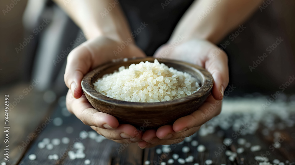 Hands holding a bowl of sea salt. Hands holding a bowl of sea salt.