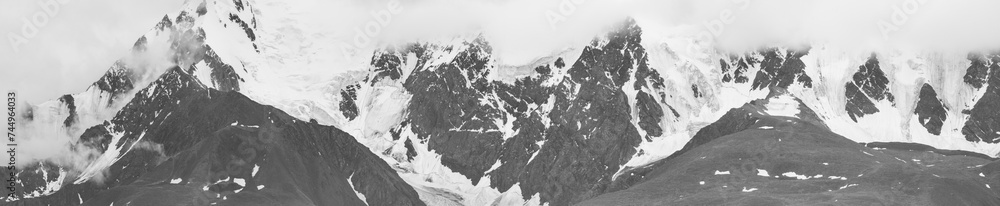 Black and white landscape, panorama. Snow-capped mountain peaks. Traveling in the mountains, climbing.