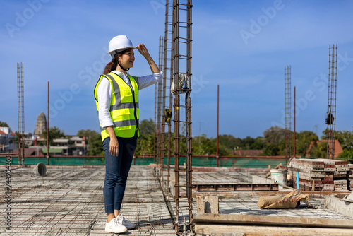 Asian woman engineering architect inspector or contractor is examining the quality of construction work of real estate development project