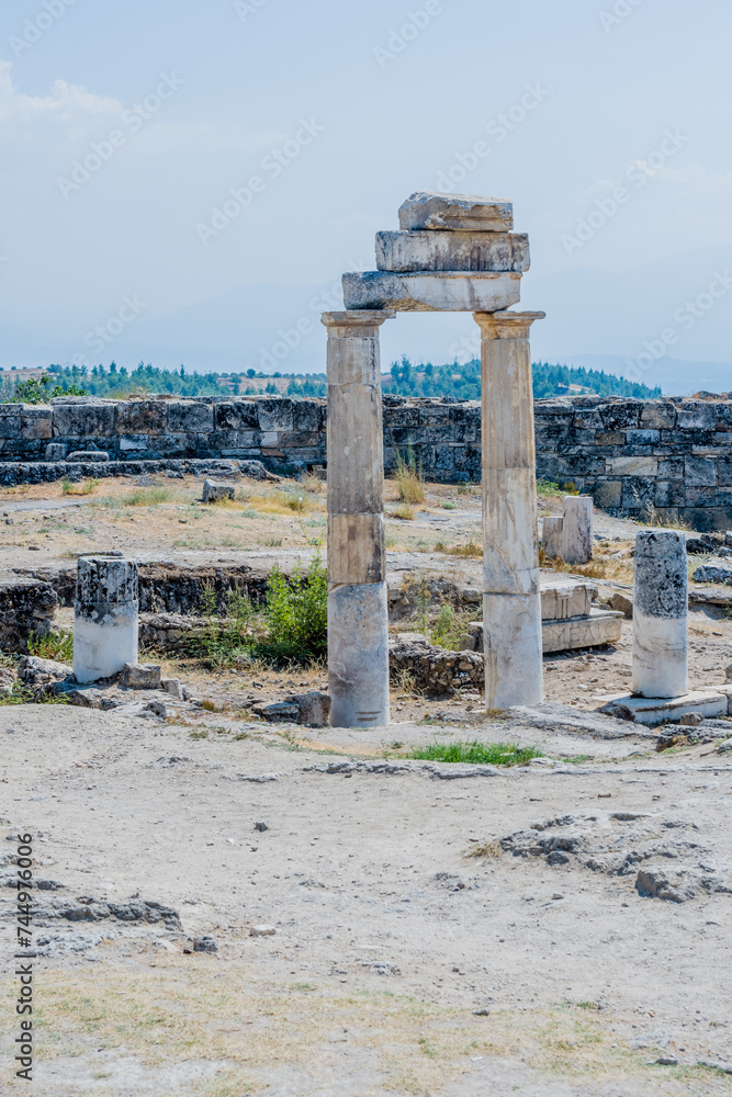 Single ancient columnar structure rising against a backdrop of expansive ruins, in Epesus Turkiye