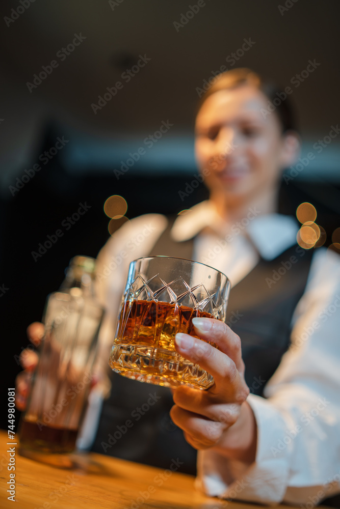 Barwoman pouring whiskey whiskey glass.. Barwoman pouring whiskey whiskey glass..