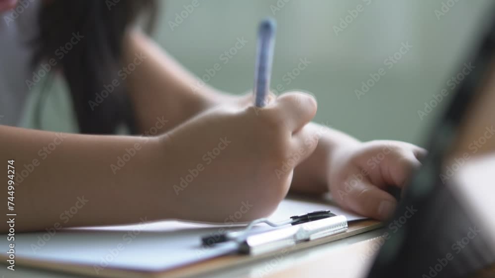 closeup hand asian child back to school or kid girl drawing or write learning by pencil on paper and computer tablet with doing homework to studying online or people learn from home on smartphone closeup hand asian child back to school or kid girl drawing or write learning by pencil on paper and computer tablet with doing homework to studying online or people learn from home on smartphone