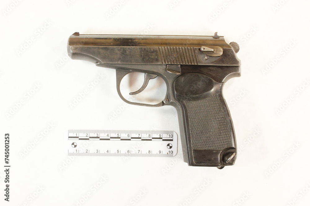 Pistol model Makarov caliber 9 mm on a white background with a scale ...