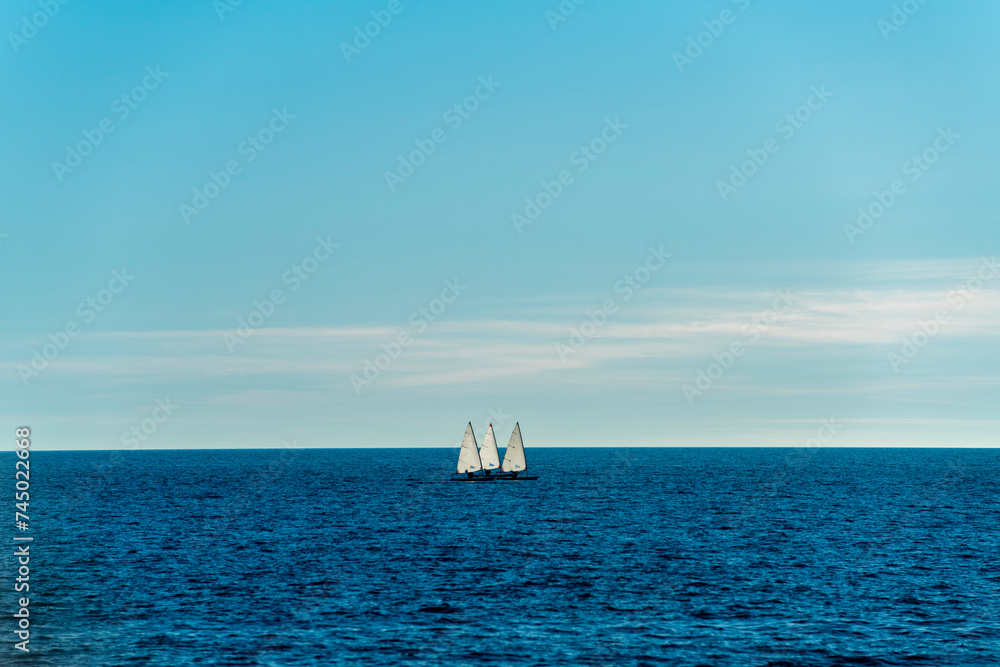 Three small sailing boats sailing on the sea Three small sailing boats sailing on the sea