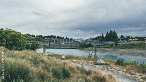 The Maclaren Footbridge is located amidst nature  suspended above the milky-turquoise waters of Lake Tekapo  New Zealand.